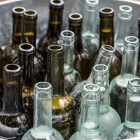 Empty wine bottles in a metal bucket.